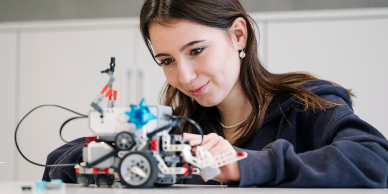 Mädchen baut an Miniatur-Roboterfahrzeug
